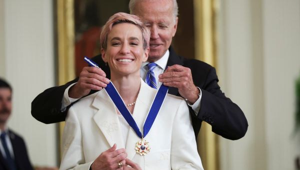 Megan Rapinoe smiles as Sue Bird takes photos of her at Medal of Freedom ceremony