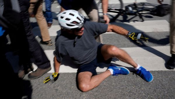 Joe Biden falls while getting off his bike after getting his 'foot caught' following beach ride with wife Jill
