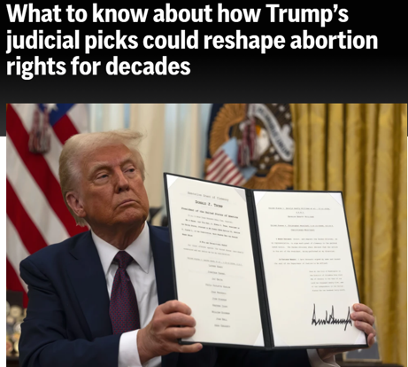 A man in a suit holds up a signed official document in an office with flags in the background. Text above discusses Trump’s judicial picks and abortion rights.