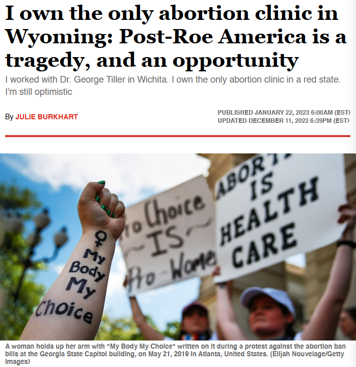 A woman holds a sign reading “My Body My Choice” at a protest against abortion bans, with another visible sign stating “Abortion is Health Care.”.